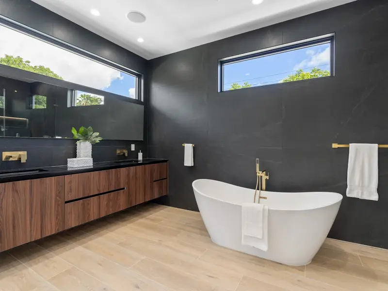 Bathroom with freestanding tub and dark tile
