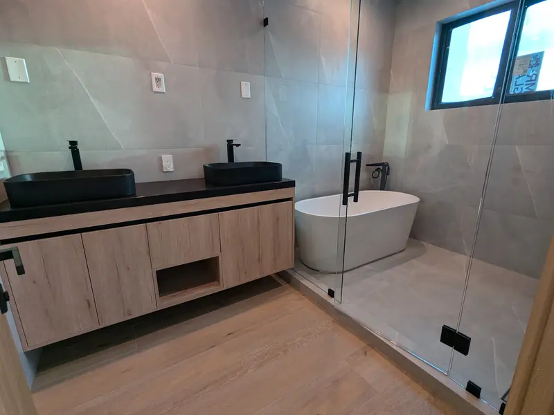 Master bath with dark vanity and freestanding tub