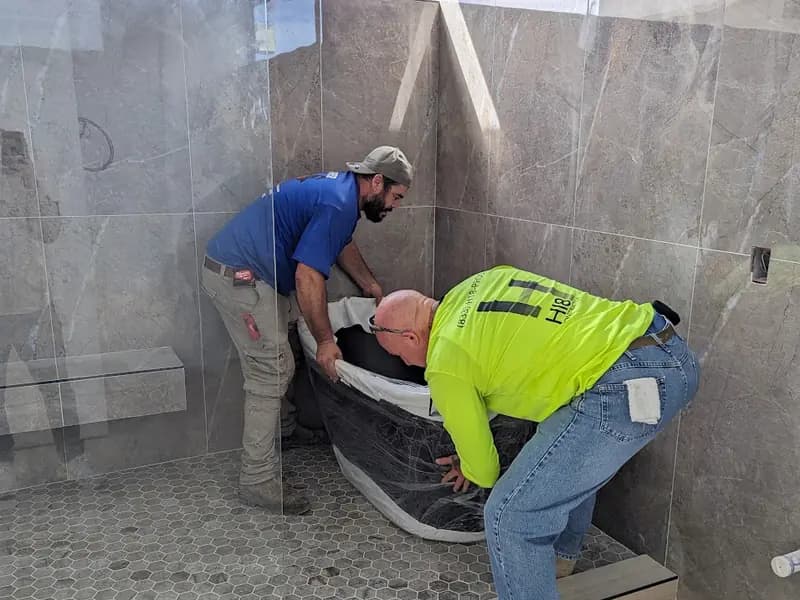 Tile setters finishing a shower