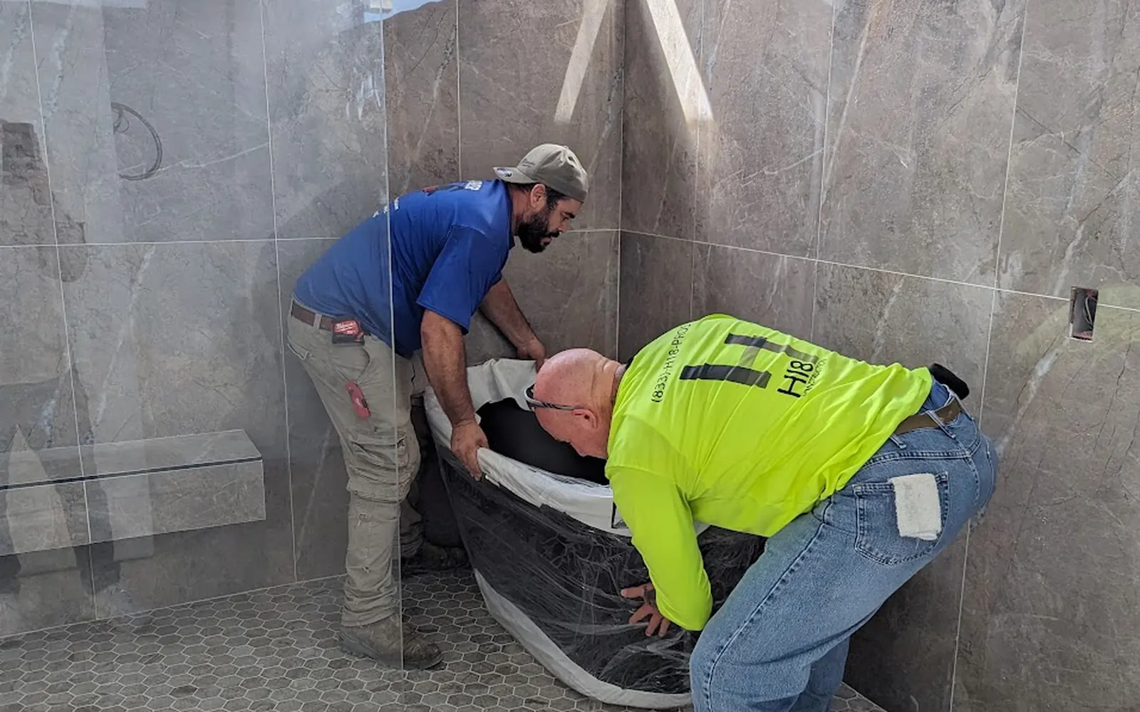 Tile setters finishing a walk-in shower
